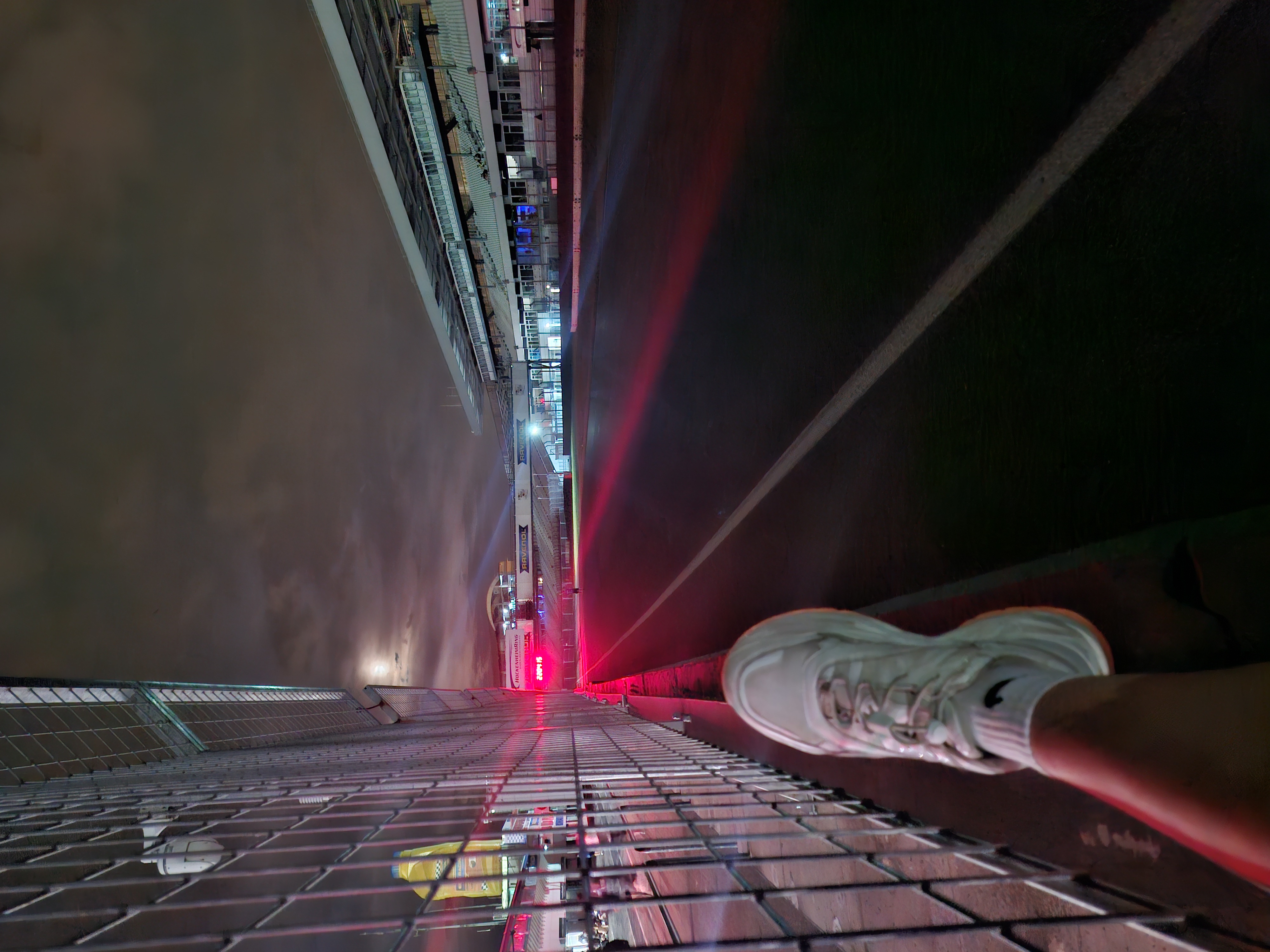 The Hockenheimring at night — the empty start-finish straight seen from behind the barrier.