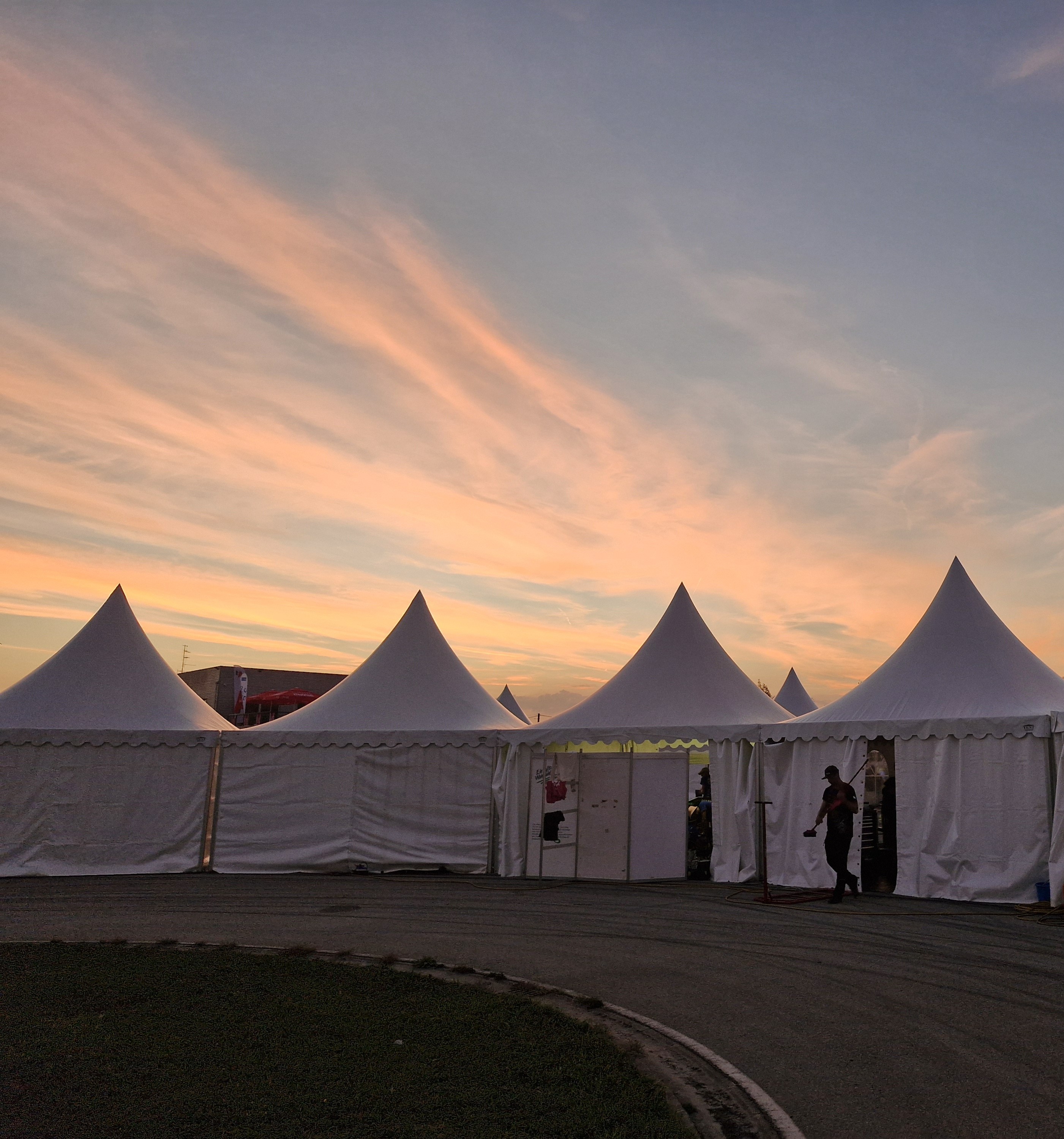 The Formula Student paddock at sunset — the team tents under a pink evening sky.